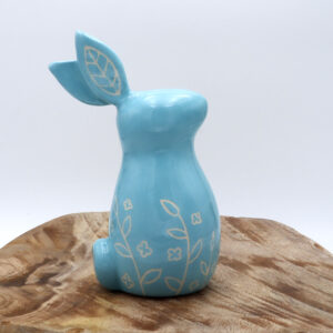 Petit lapin en faïence engobé en bleu avec des motifs floraux gravés