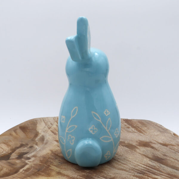 Petit lapin en faïence engobé en bleu avec des motifs floraux gravés