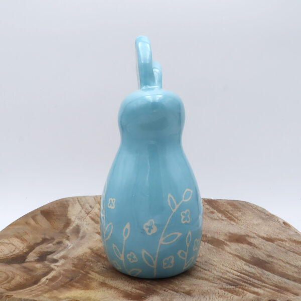 Petit lapin en faïence engobé en bleu avec des motifs floraux gravés