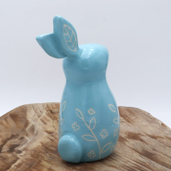 Petit lapin en faïence engobé en bleu avec des motifs floraux gravés