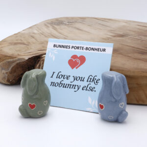 Deux lapins amoureux en céramique dans une boite en carton accompagné d'une citation