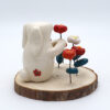 Lapin en céramique posé sur un rondeau de bois entouré de fleurs - Victoria Céramique